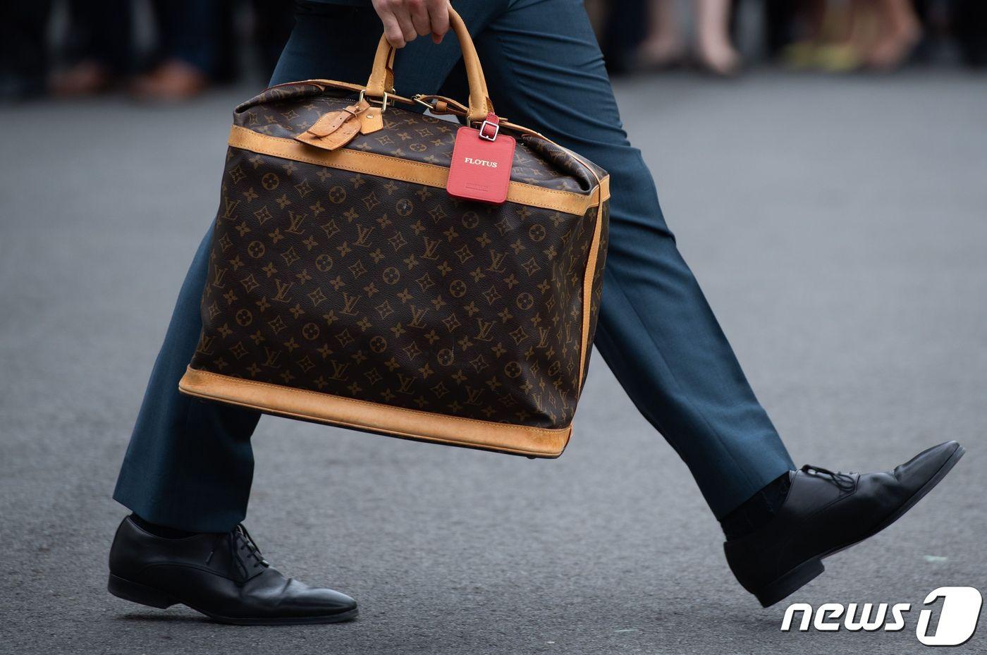 2020년 10월 27일(현지시간) 미국 워싱턴 백악관에서 도널드 트럼프 미국 대통령 부인 멜라니아 여사의 보좌관이 전용헬기를 타는 멜라니아 여사의 루이뷔통 가방을 들고 있다. (사진은 기사 내용과 무관함)  ⓒ AFP=뉴스1 ⓒ News1 