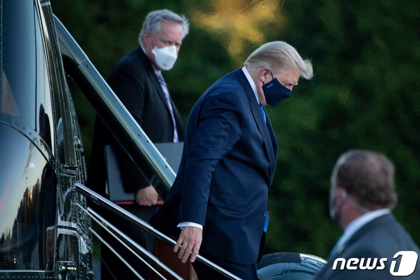 도널드 트럼프 미국 대통령이 2일(현지시간) 코로나19 확진 판정을 받은 후 메릴랜드주 베데스다에 있는 월터 리드 군병원에 도착해 마크 메도우 비서실장과 전용헬기를 내리고 있다. ⓒ AFP=뉴스1 ⓒ News1 우동명 기자