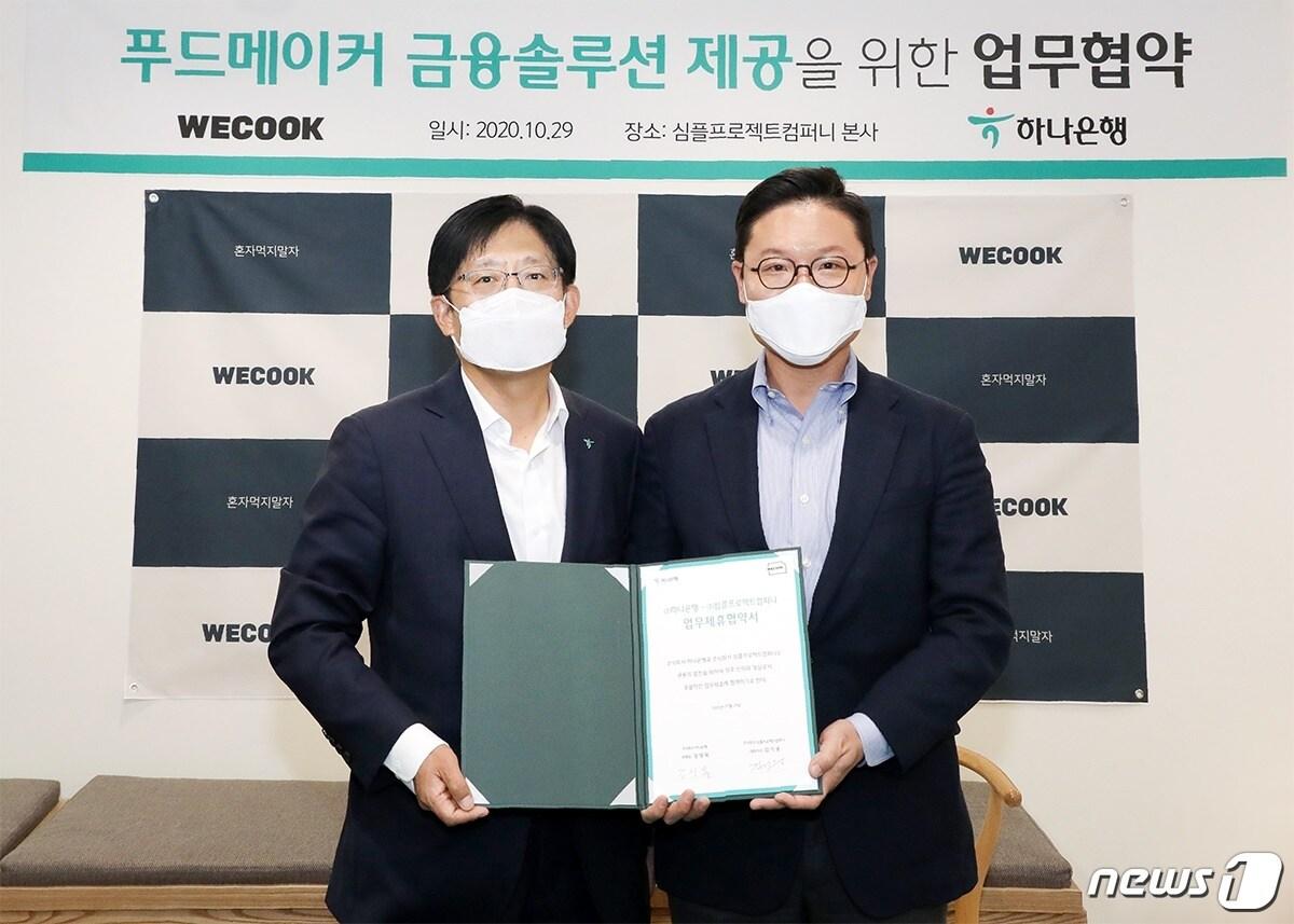 본문 이미지 - 하나은행은 29일 오후 심플프로젝트컴퍼니 본사에서 (주)심플프로젝트컴퍼니와 업무 협약을 체결했다. 강성묵(왼쪽) 하나은행 중앙영업2그룹 부행장과 (주)심플프로젝트컴퍼니 김기웅 대표이사가 협약을 체결하고 기념촬영을 하고 있다. (사진제공 = 하나은행) ⓒ 뉴스1