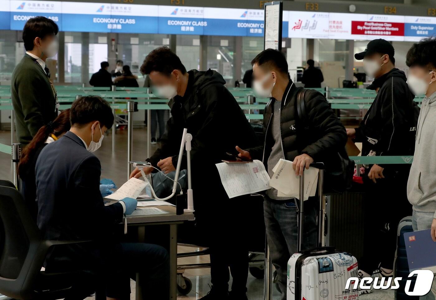 본문 이미지 - 12일 오후 인천국제공항 1터미널 출국장 중국 항공기 체크인카운터에서 승객들이 신종 코로나바이러스 감염증(코로나19)에 걸리지 않았다는 것을 증명하는 음성확인서를 두 장을 공항 관계자에게 보여주고 있다. 중앙재난안전대책본부(중대본)에 따르면 11일 0시부터 우리나라에서 중국으로 가는 비행기 탑승객은 PCR(유전자 증폭) 검사 음성 확인서 2장을 제출해야 한다.2020.11.12/뉴스1 ⓒ News1 정진욱 기자