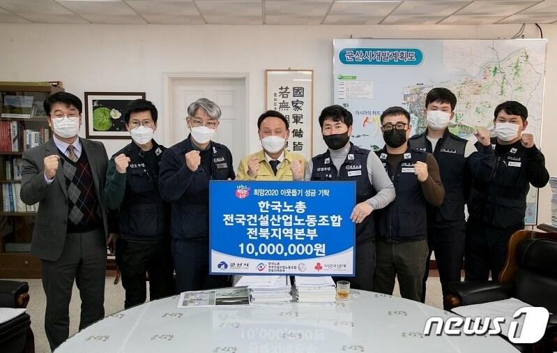 본문 이미지 - 한국노총 전국건설산업노조 전북본부 직원들이 군산시에 이웃돕기 성금을 기탁하고 있다. /ⓒ 뉴스1