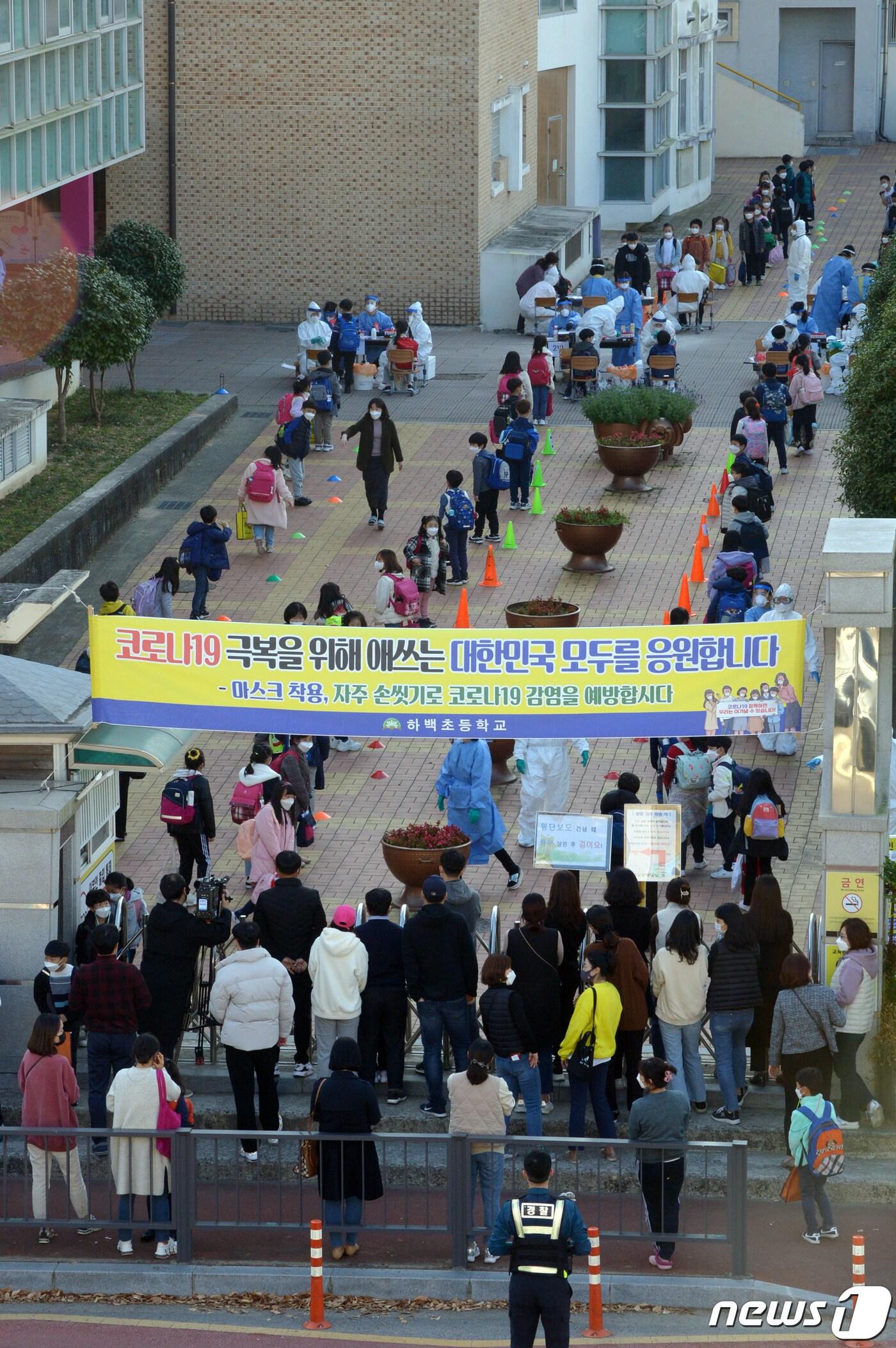 본문 이미지 - 광주 지역에서 신종 코로나바이러스 감염증(코로나19) 확진자가 속출하고 있는 가운데 16일 오후 광주 북구 하백초등학교에서 해당 학교 학생들이 진단 검사를 받기 위해 길게 줄지어 서있다. 이날 오후 해당 학교 학생 2명이 코로나19에 확진돼 시는 선별진료소를 설치, 전수검사를 진행하고 있다.2020.11.16 /뉴스1 ⓒ News1 정다움 기자