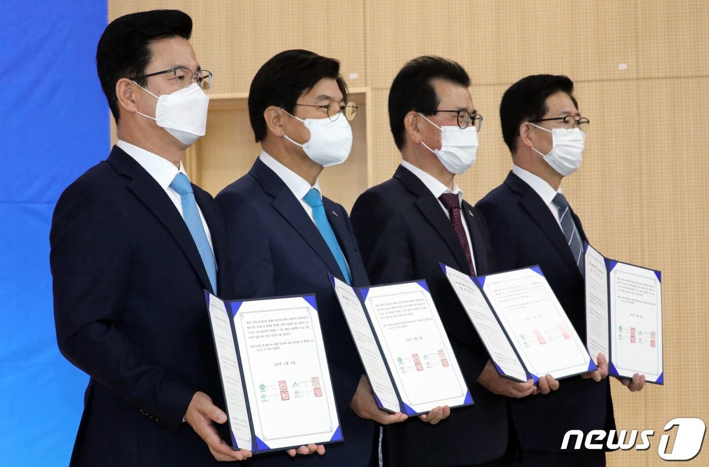 본문 이미지 - 허태정 대전시장(왼쪽부터)과 이춘희 세종시장, 이시종 충북지사, 양승조 충남지사가 지난해 11월 20일 세종시 국립세종수목원 대강당에서 열린 '제29회 충청권 행정협의회'에서 충청권 광역생활경제권(메가시티) 구축 협력을 위한 합의 서명을 마친 뒤 파이팅을 외치고 있다.  2020.11.20/뉴스1 ⓒ News1 장수영 기자
