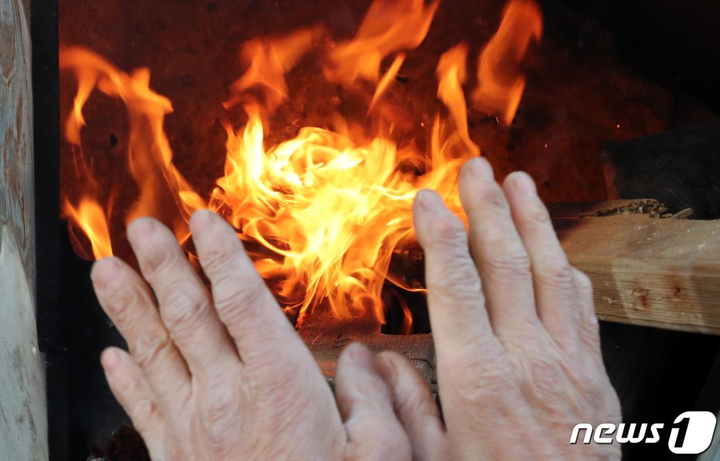 본문 이미지 - 25일 대전·충남은 아침 기온이 -10도 안팎을 보이는 강추위가 이어질 것으로 예보됐다. 대전 유성구 노은농수산물도매시장에서 상인이 모닥불로 추위를 녹이고 있다. 2020.11.23/뉴스1 ⓒ News1 김기태 기자