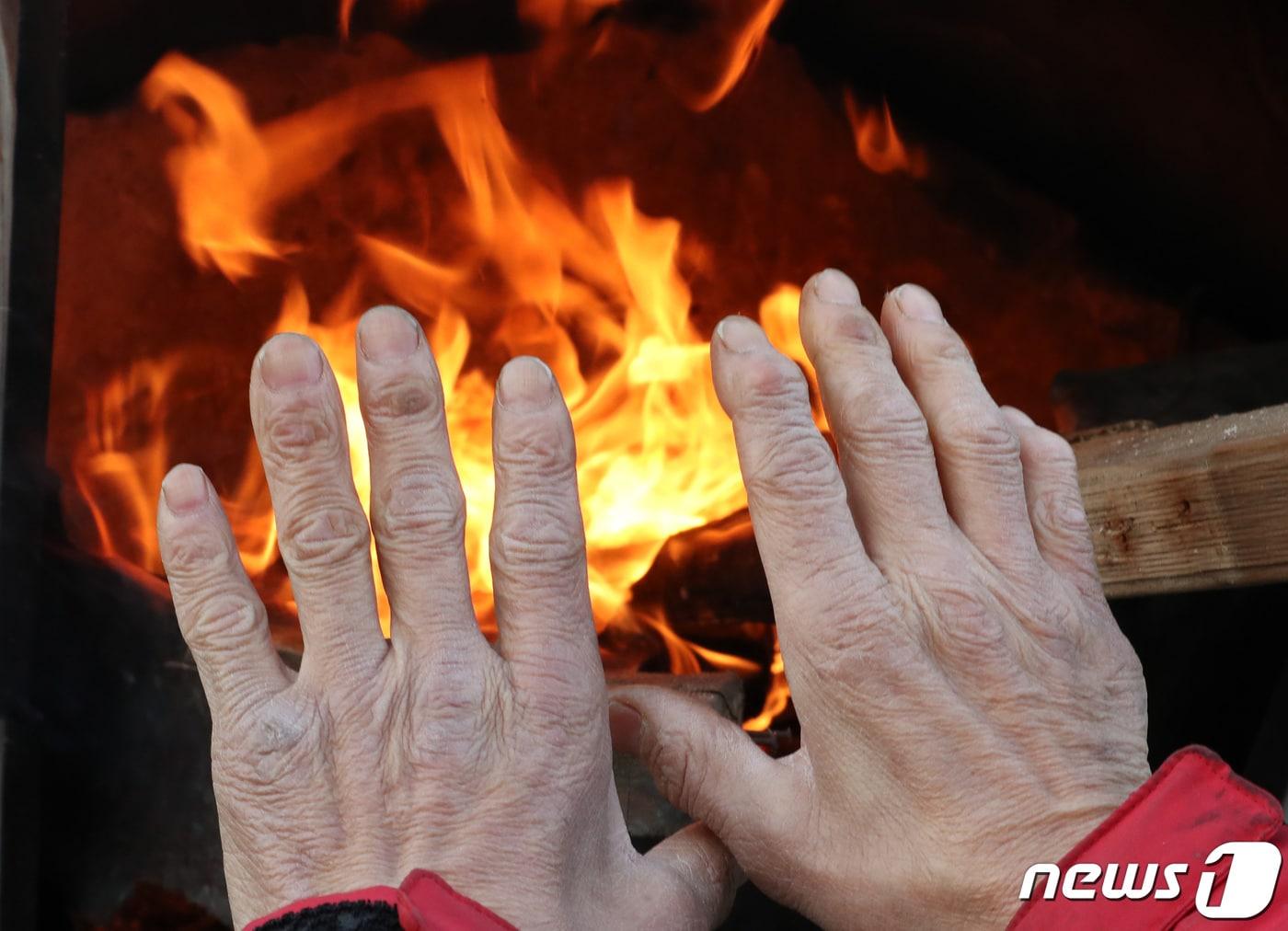 본문 이미지 - 대전 유성구 노은농수산물도매시장에서 상인이 모닥불로 추위를 녹이고 있다. /뉴스1 ⓒ News1 김기태 기자