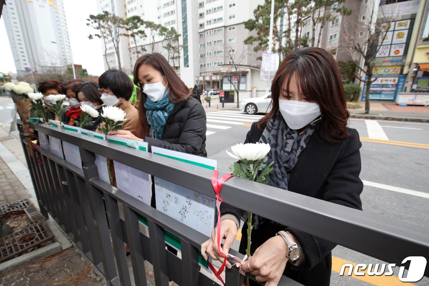 본문 이미지 - 23일 광주 북구 운암동 한 어린이보호구역에서 운암1동행정복지센터 직원들이 최근 해당 구역에서 교통사고로 숨진 3살 여아를 추모하며 안전펜스에 국화를 걸고 있다. 2020.11.23/뉴스1 ⓒ News1 황희규 기자
