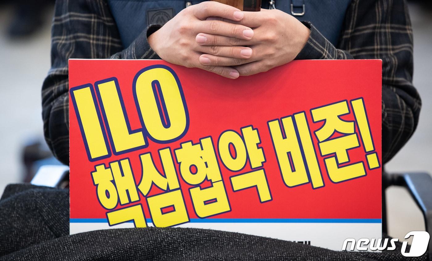 본문 이미지 - 26일 서울 중구 프레스센터 기자회견장에서 열린 정부노조법개악 반대, ILO핵심협약비준 노동시민종교단체 공동대책위원회 결성 기자회견에서 한 노동자가 'ILO핵심협약 비준!' 손팻말을 들고 있다. 2020.11.26/뉴스1 ⓒ News1 유승관 기자