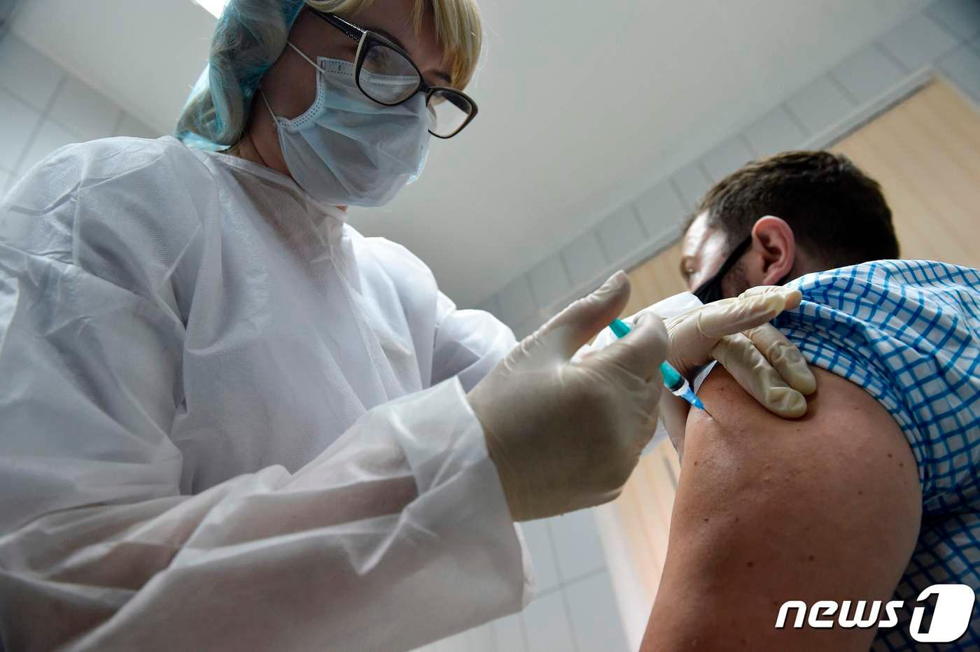 러시아가 자체 개발한 코로나19 백신을 한 남성이 맞고 있다.  ⓒ AFP=뉴스1