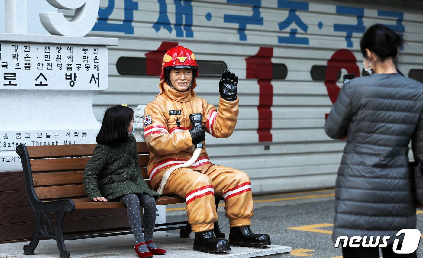 국가직 전환 이후 첫 소방의 날을 하루 앞둔 8일 오후 서울 종로소방서 앞에서 어린이들이 소방관 동상과 기념촬영을 하고 있다. 2020.11.8/뉴스1 ⓒ News1 박지혜 기자