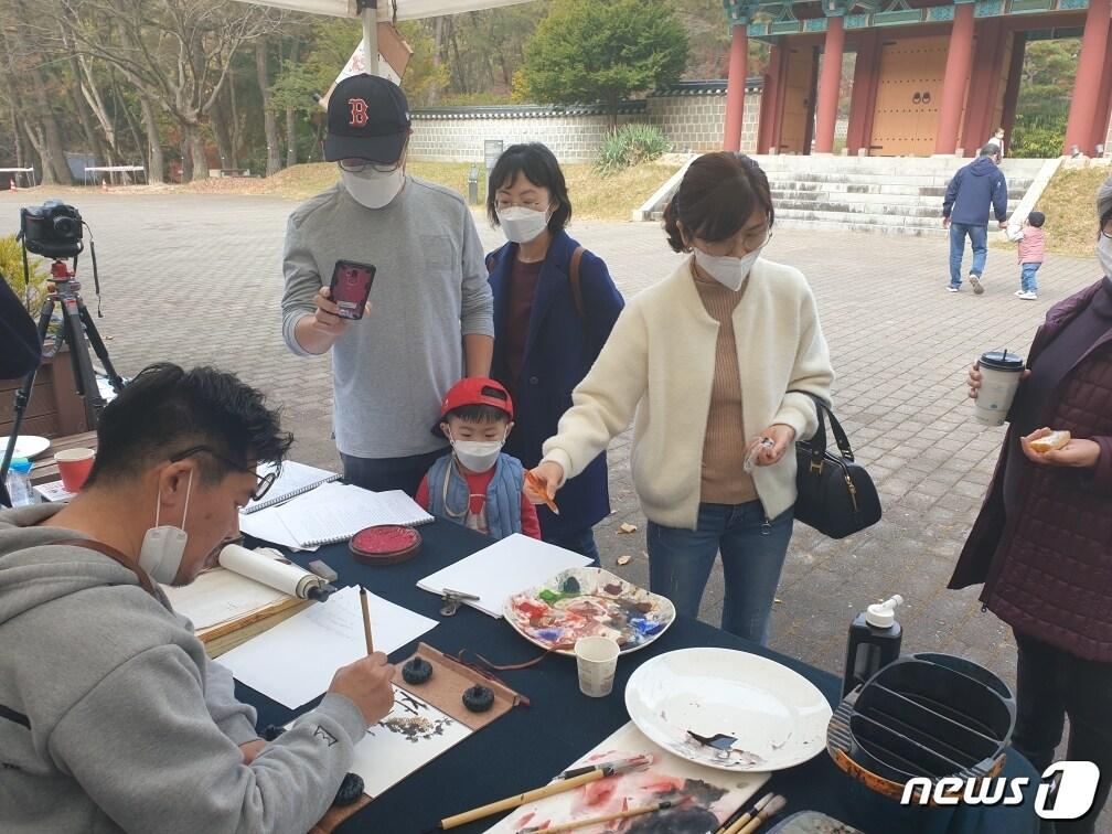 본문 이미지 - 충남 부여군 부소산을 찾은 관광객들이 백제문화체험 프로그램에 관심을 보이고 있다.(부여군 제공)ⓒ 뉴스1