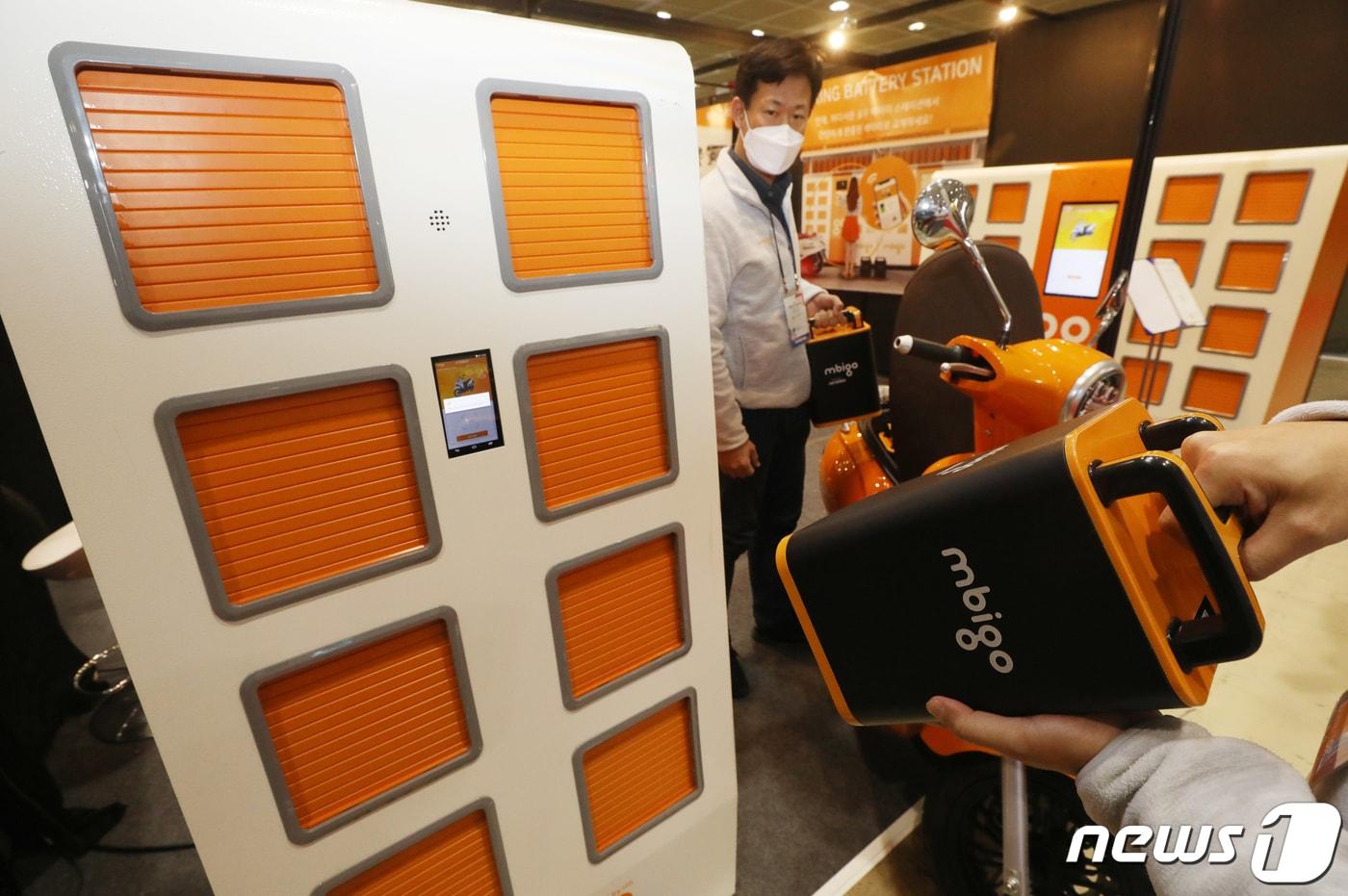 본문 이미지 - 지난 2020년  서울 강남구에서 열린 대한민국 지식대전에서 관계자들이 전기 이륜차의 배터리를 교체해 충전할 수 있는 배터리충전스테이션을 소개하고 있다. 2020.12.1/뉴스 ⓒ News1 송원영 기자