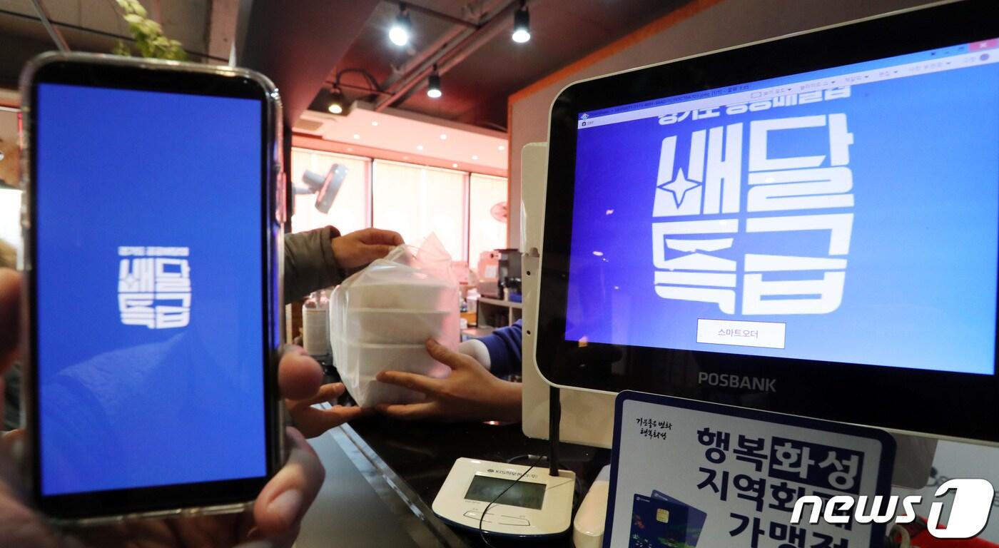 본문 이미지 - 경기도 공공배달앱 ‘배달특급’ 이용자가 적어 사업의 지속 여부를 고민해야 한다는 지적이 나오고 있다. 사진은 배달특급 시범 서비스가 시작된 2020년 12월1일 오후 경기도 화성시내 한 음식점에서 점주가 앱을 통해 주문된 음식을 전달하고 있다. 2020.12.1/뉴스1 ⓒ News1 조태형 기자