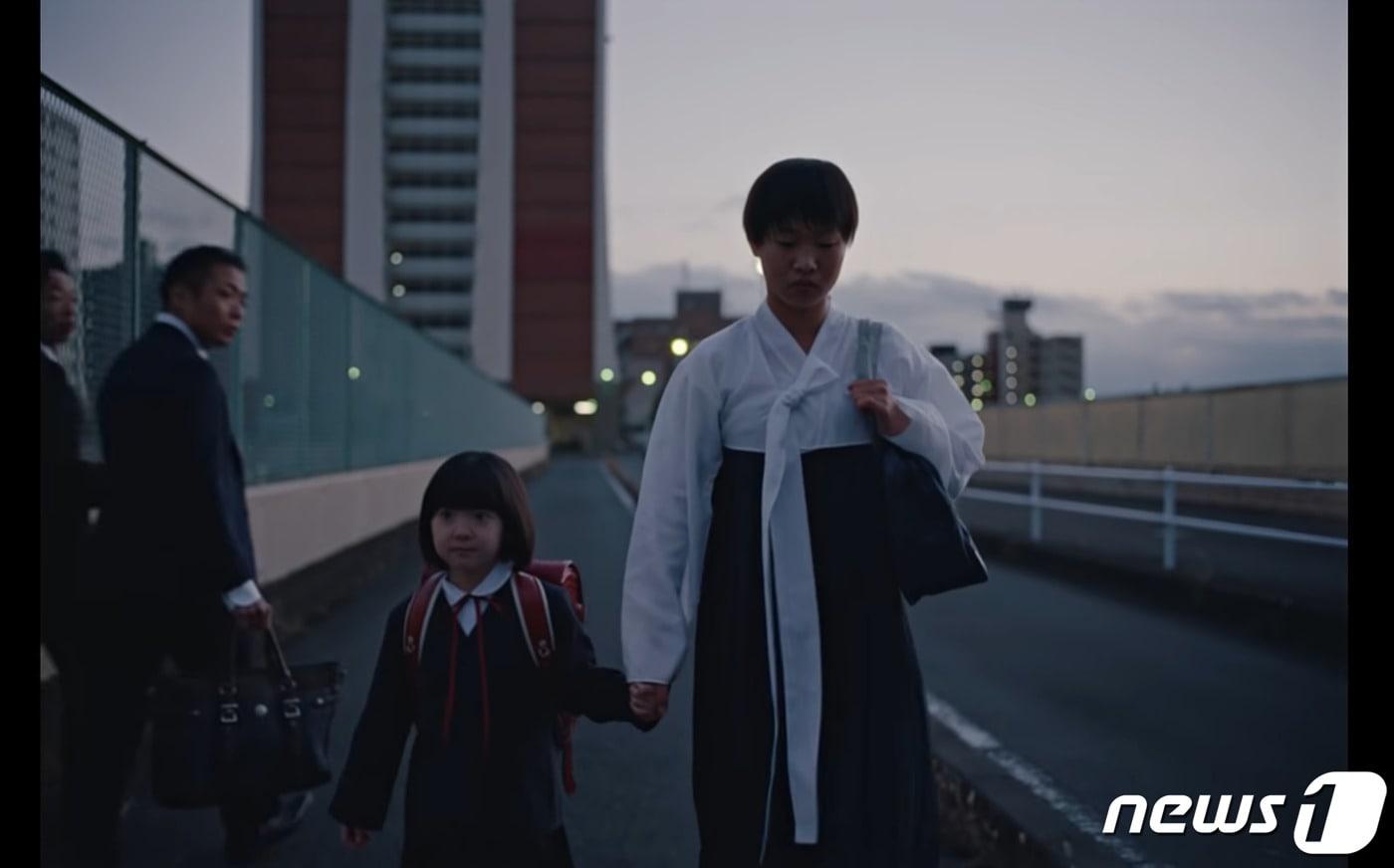 본문 이미지 - 지난달 27일 나이키 재팬(NIKE JAPAN)이 공개한 온라인 동영상 광고 속 한 장면. 검정 치마저고리를 입고 가는 재일 조선인 여학생에게 따가운 시선이 쏟아진다. ('나이키 재팬' 유튜브 갈무리)ⓒ 뉴스1