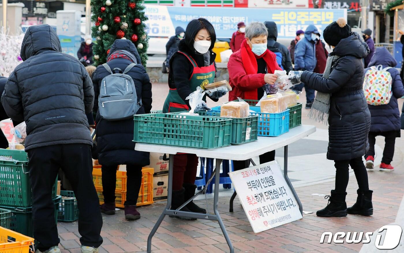 본문 이미지 - 16일 오전 인천시 미추홀구 주안역에서 (사)사랑의쌀나눔운동본부중앙회 관계자들이 코로나19로 무료급식소 운영을 못하자 독거노인들에게 빵을 나눠주고 있다.2020.12.16/뉴스1 ⓒ News1 정진욱 기자