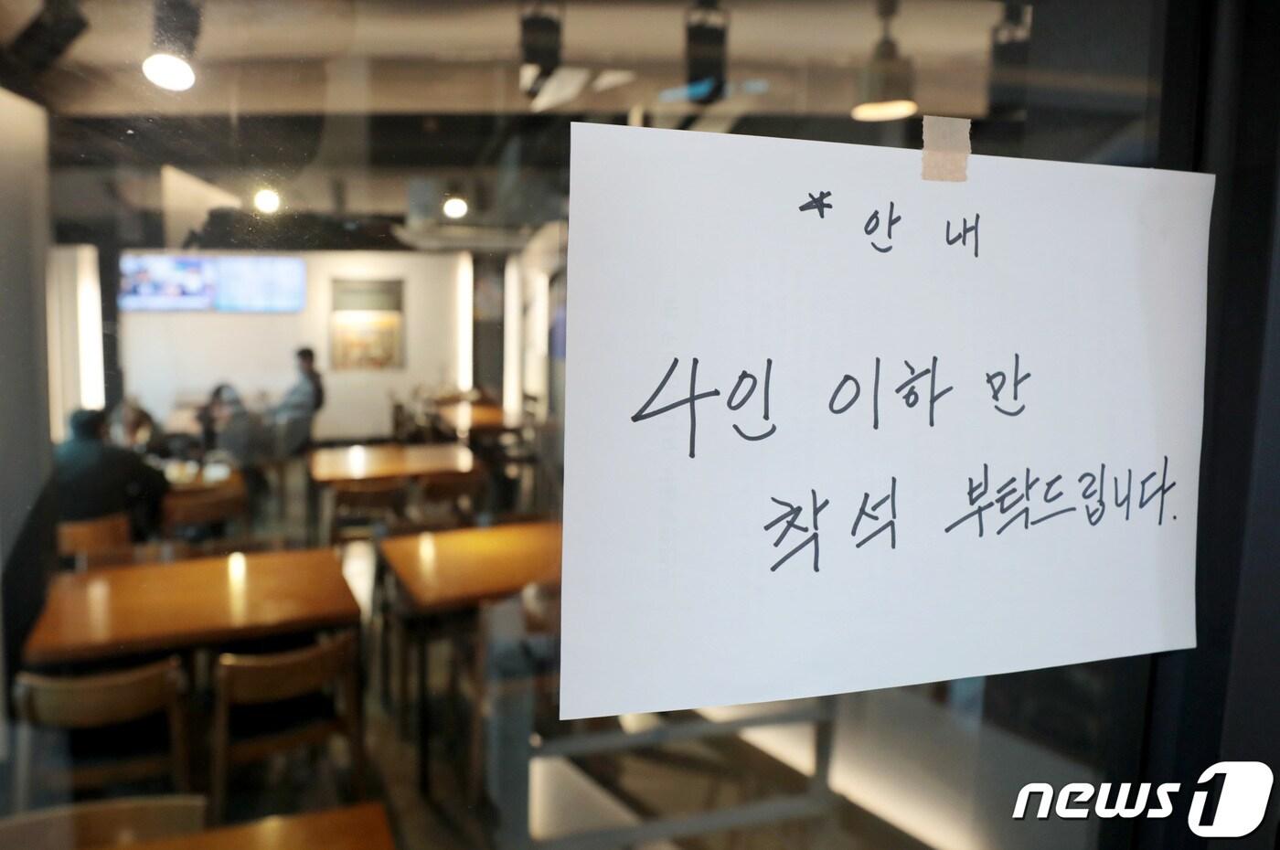 본문 이미지 - 정부의 연말연시 특별 방역대책의 일환인 '식당 5인 이상 금지' 조치가 시행된 24일 서울의 한 음식점에 4인 이하만 착석 해달라는 안내문이 붙어 있다.  2020.12.24/뉴스1 ⓒ News1 이성철 기자