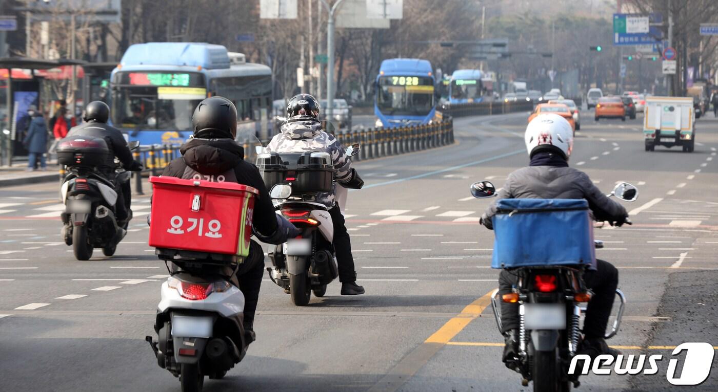 28일 서울 광화문 사거리에서 음식배달대행 종사자가 도로를 주행하고 있다. 농림축산식품부는 신종 코로나바이러스 감염증(코로나19)으로 위축된 외식업계를 돕기 위해 배달앱을 통한 비대면 주문·결제에 대해 오는 29일 오전 10시부터 회당 2만원 이상 총 4회를 주문한 사람에게 1만원을 환급한다고 밝혔다. 2020.12.28/뉴스1 ⓒ News1 황기선 기자