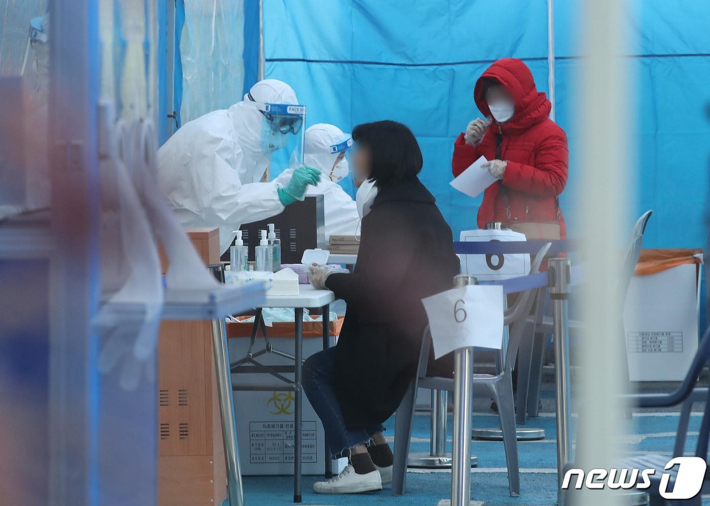 본문 이미지 - 28일 오후 서울 한 보건소에 마련된 신종 코로나바이러스 감염증(코로나19) 선별진료소를 찾은 시민들이 검사를 받고 있다. 2020.12.28/뉴스1 ⓒ News1 임세영 기자