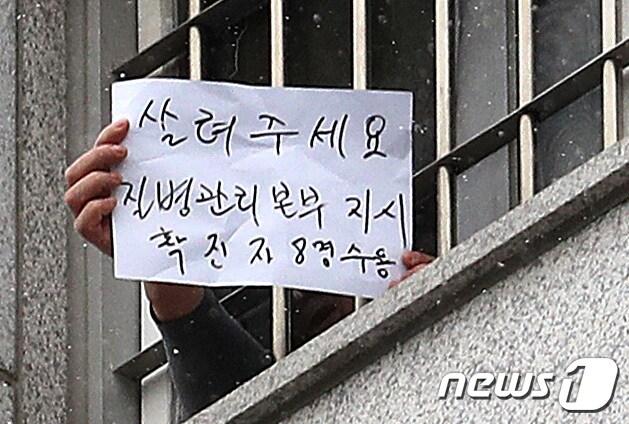 본문 이미지 - 대규모 집단감염이 발생한 서울 동부구치소에서 233명이 추가 확진되면서 누적 확진자가 761명으로 집계된 29일 서울 송파구 동부구치소에서 한 수용자가 자필로 '살려주세요'라고 쓴 문구를 취재진에게 보여주고 있다. 2020.12.29/뉴스1 ⓒ News1 이성철 기자