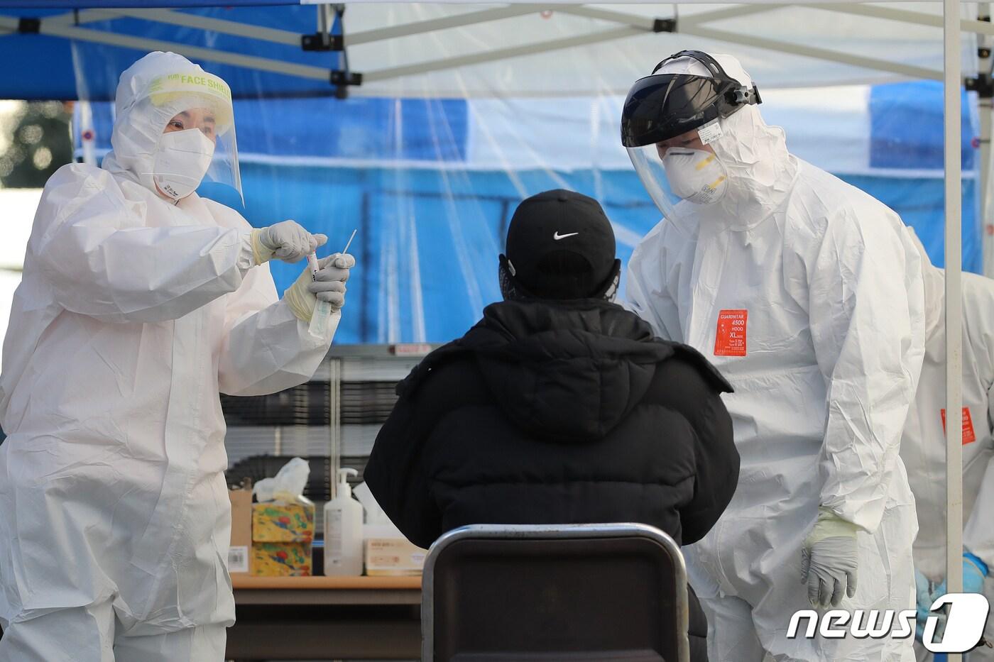 본문 이미지 - 의료진이 한 시민의 검체를 채취하고 있다./뉴스1 ⓒ News1 공정식 기자