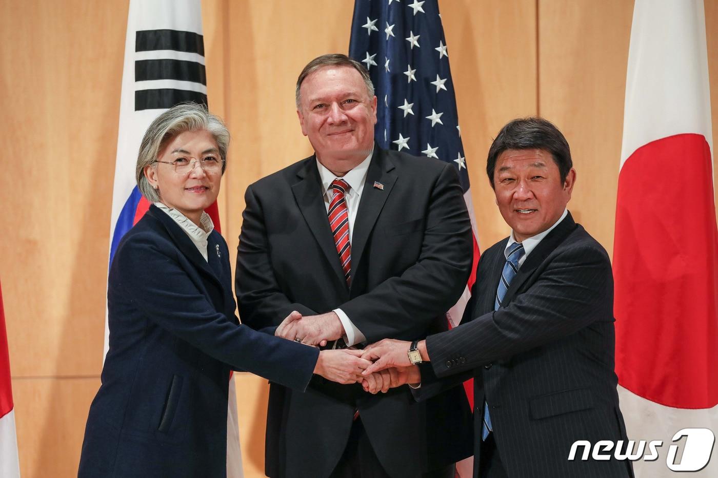본문 이미지 - 강경화 외교부장관이 15일(현지시간) 독일 뮌헨에서 마이크 폼페이오 미 국무장관, 모테기 도시미쓰 일본 외무상을 만나 한미일 외교장관회담을 하기 앞서 손을 맞잡고 있다. (외교부 제공)2020.2.15/뉴스1