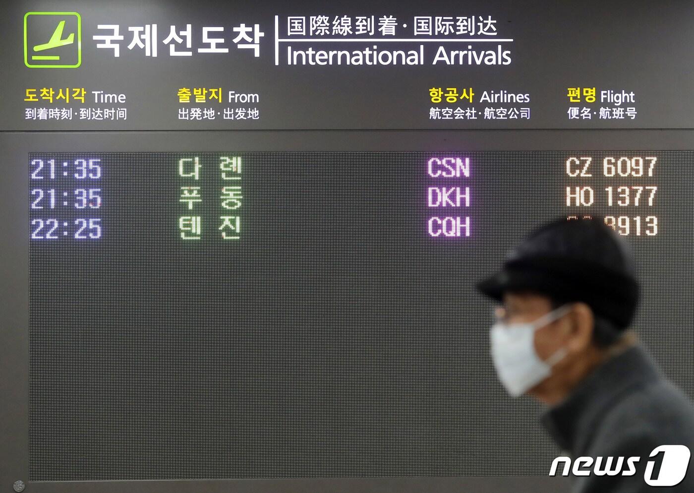본문 이미지 - 정부는 제주국제공항 국제선 도착 전광판 앞으로 마스크를 쓴 여행객들이 지나가고 있다.2020.2.2/뉴스1 ⓒ News1 오현지 기자