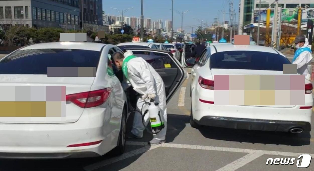 본문 이미지 - 22일 오전 충북 청주고속버스터미널 인근 택시승강장에서 개인택시 청주시지부 관계자들이 택시를 소독하고 있다. (독자 제공) ⓒ 뉴스1