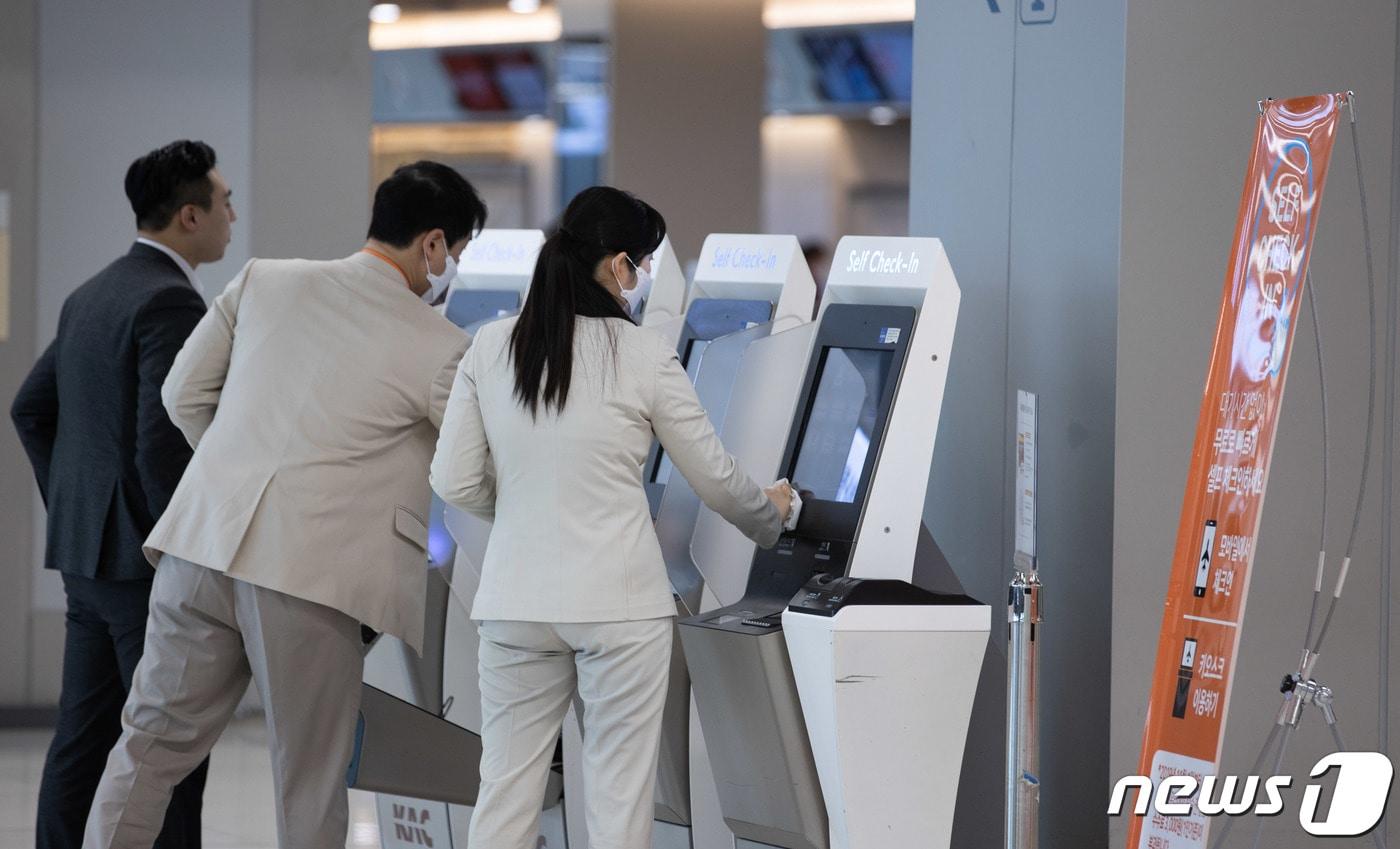 본문 이미지 -   서울 강서구 김포공항 국내선에서 항공사 관계자들이 셀프 체크인 기기를 소독하고 있다.  /뉴스1 ⓒ News1 이재명 기자