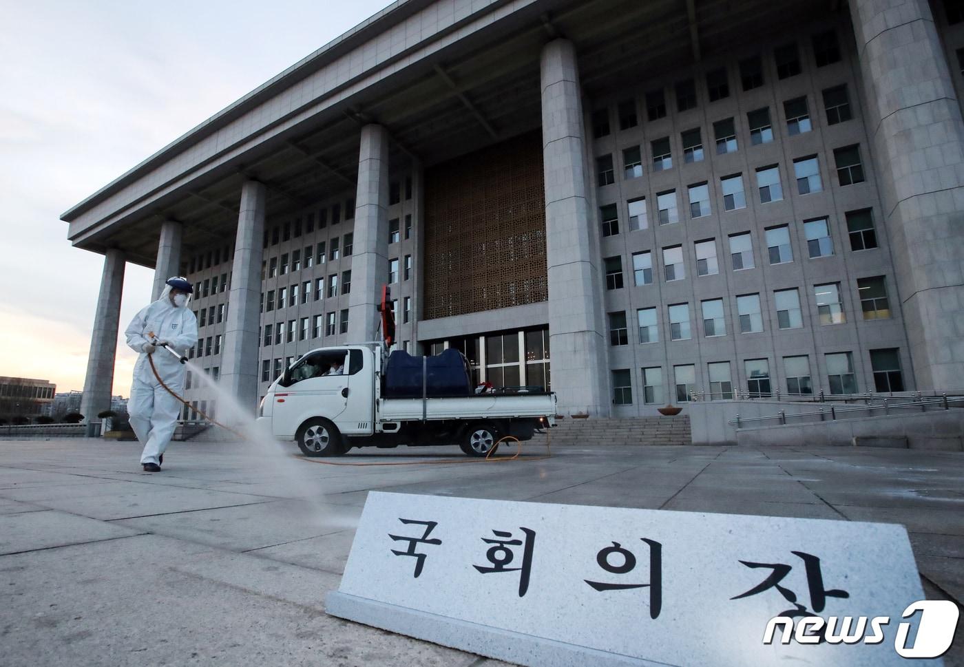 본문 이미지 - 지난해 2월24일 오후 서울 여의도 국회에서 코로나19 방역 관계자들이 방역작업을 하고 있다. 당시 국회는 코로나19 확산 사태와 관련해 사상 처음으로 2월24일 오후 6시부터 26일 오전 9시까지 국회 본관과 의원회관을 폐쇄하기로 했다. 2020.2.24/뉴스1 ⓒ News1 김명섭 기자