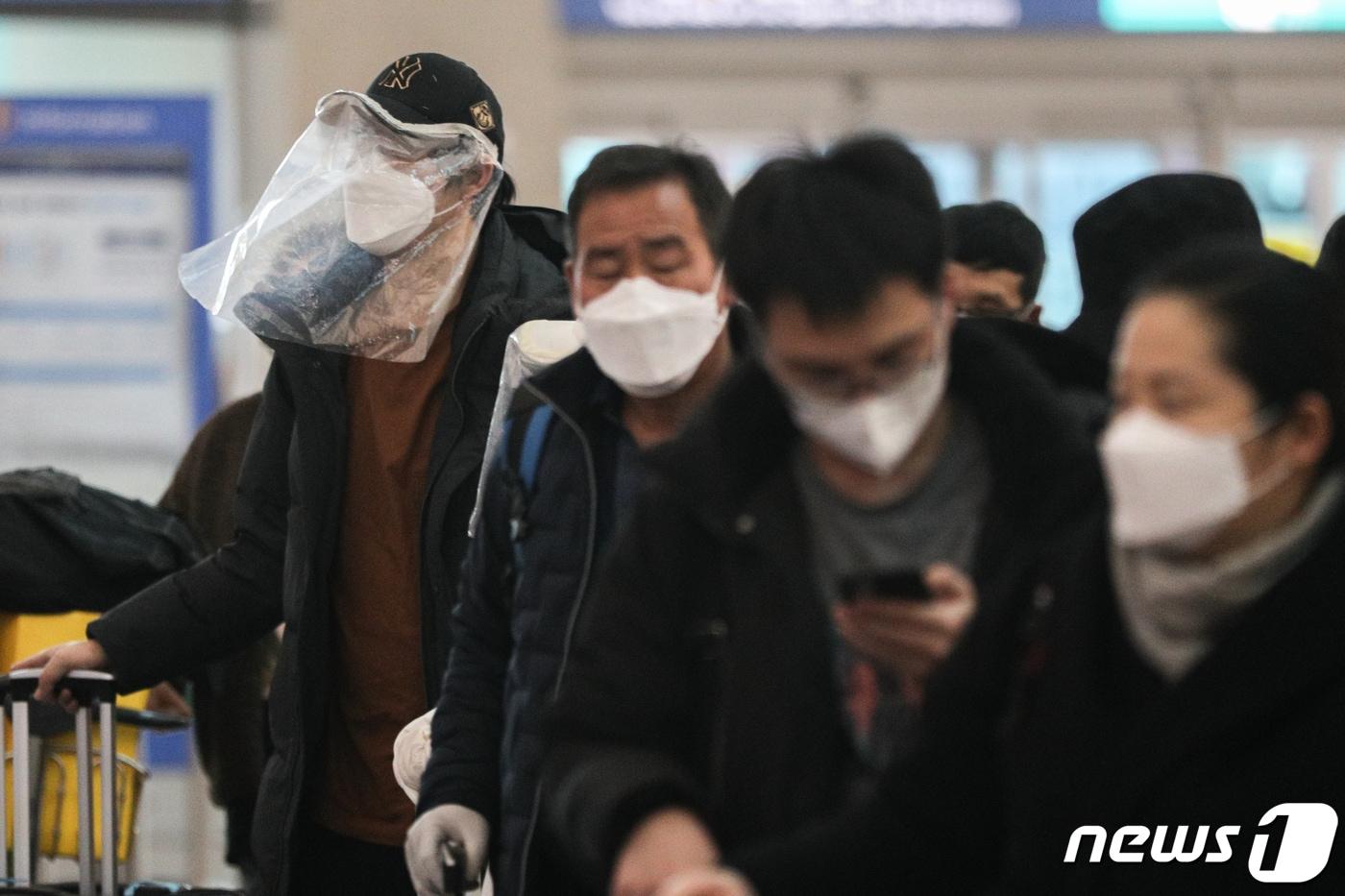 본문 이미지 - 25일 인천국제공항 제1터미널 출국장에서 비닐을 쓴 중국인 관광객들이 출국 수속을 하고 있다. 2020.2.25/뉴스1 ⓒ News1 성동훈 기자