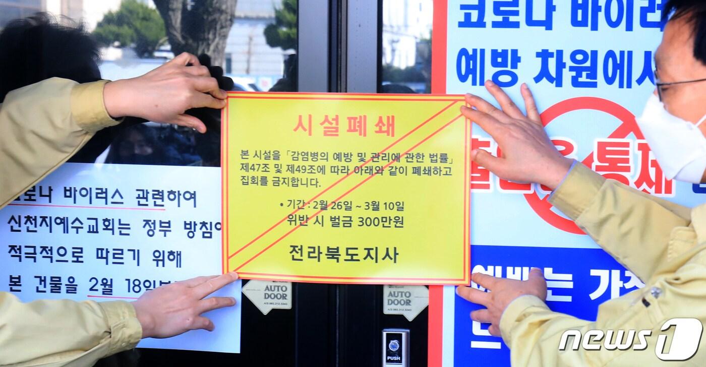 26일 전북 전주시 신천지 하늘문화센터에서 전북도 관계자들이 '감염병 예방 및 관리에 관한 법률'의 행정명령을 집행해 시설폐쇄 스티커를 붙이고 있다. 2020.2.26/뉴스1 ⓒ News1 유경석 기자