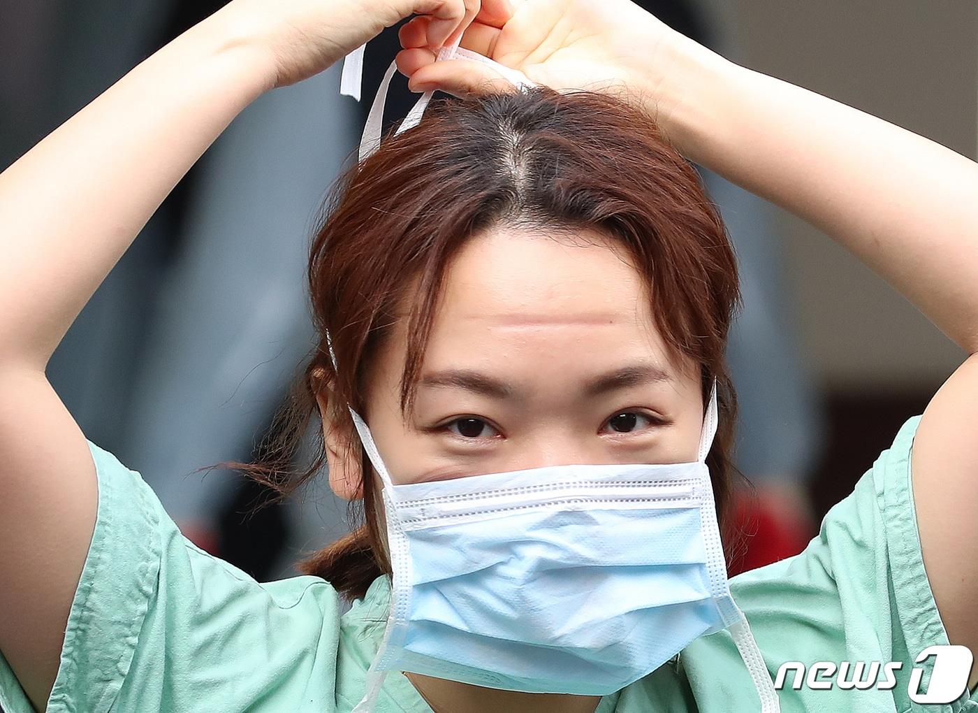 본문 이미지 - 지난 2월 27일 오전 신종 코로나바이러스 감염증(코로나19) 지역거점병원인 계명대 대구동산병원에서 밤새도록 코로나19와 싸우며 확진자를 돌보고 나오는 의료진이 보호구를 벗고 마스크를 착용하는 순간 얼굴에 눌린 자국이 선명하게 남아 있다. 2020.2.27/뉴스1 ⓒ News1 공정식 기자