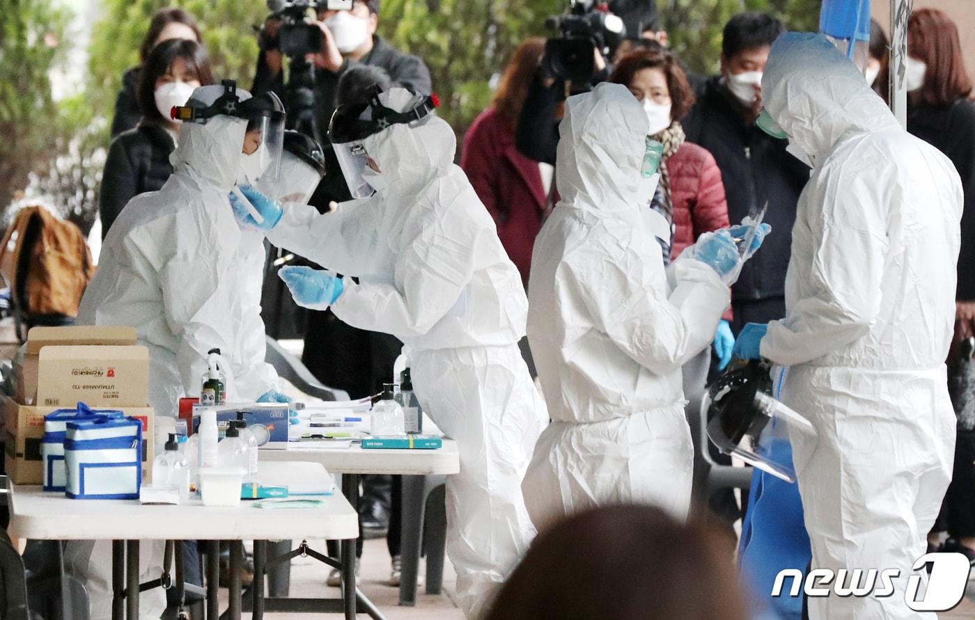 본문 이미지 - 10일 오전 서울 구로구 코리아빌딩 앞에 마련된 선별진료소에서 의료진들이 코로나19(신종코로나 바이러스 감염증) 검진에 앞서 보호장구를 갖추고 있다. ⓒ News1 민경석 기자