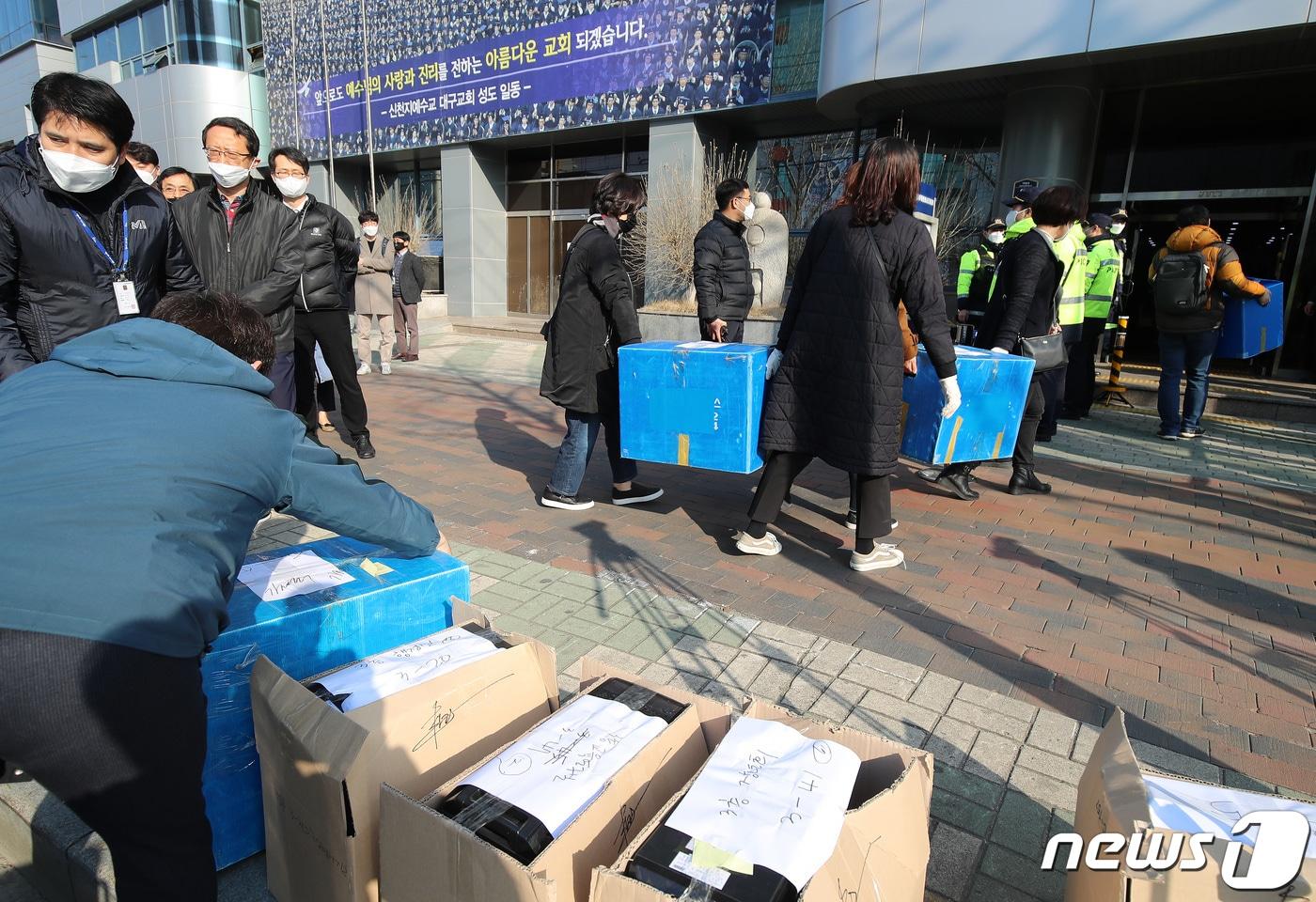 본문 이미지 - 지난 3월17일 오전 대구시 공무원들이 신천지 대구교회에 대한 행정조사를 통해 확보했던 컴퓨터 등 자료를 다시 들고 교회 건물로 들어가고 있다. 대구시와 경찰 등은 지난 12일 행정조사를 통해 컴퓨터 40여 대 등 신천지 내부 자료를 확보했지만, 보안프로그램으로 잠겨 있어 자료를 제대로 살펴보지 못한 것으로 알려졌다. 2020.3.17/뉴스1 ⓒ News1 공정식 기자
