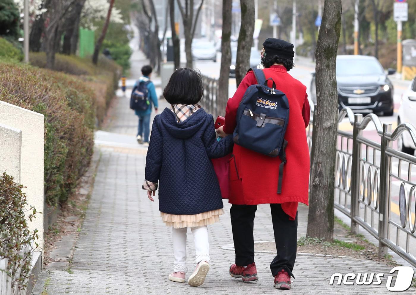 본문 이미지 - 한  초등학교에서 학생이 보호자와 함께 학교를 나서고 있다. 2020.3.17 ⓒ 뉴스1 김기태 기자