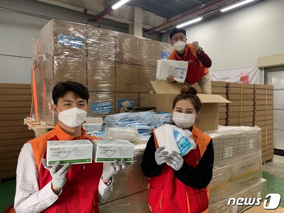 본문 이미지 - 중국 우시시 정부가 보낸 코로나19 방역 마스크를 SK하이닉스 구성원들이 들어 보이고 있다.(SK하이닉스 제공)2020.03.18/뉴스1 ⓒ 뉴스1