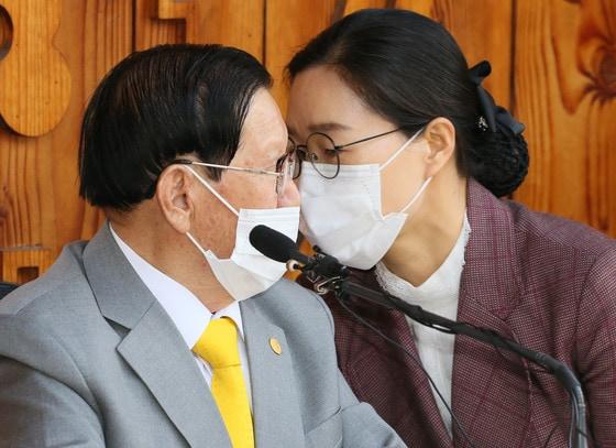 본문 이미지 - 귀가 어두운 이만희 신천지예수교 증거장막성전 총회장이 지난 2일 오후 기자회견 때 김평화씨로부터 기자들의 질문 내용을 전달받고 있다. 변상욱 앵커는 이만희 사후, 상속을 놓고 부인파-제2부인파 등이 내부 다툼 중이라고 했다. ⓒ News1 허경 기자