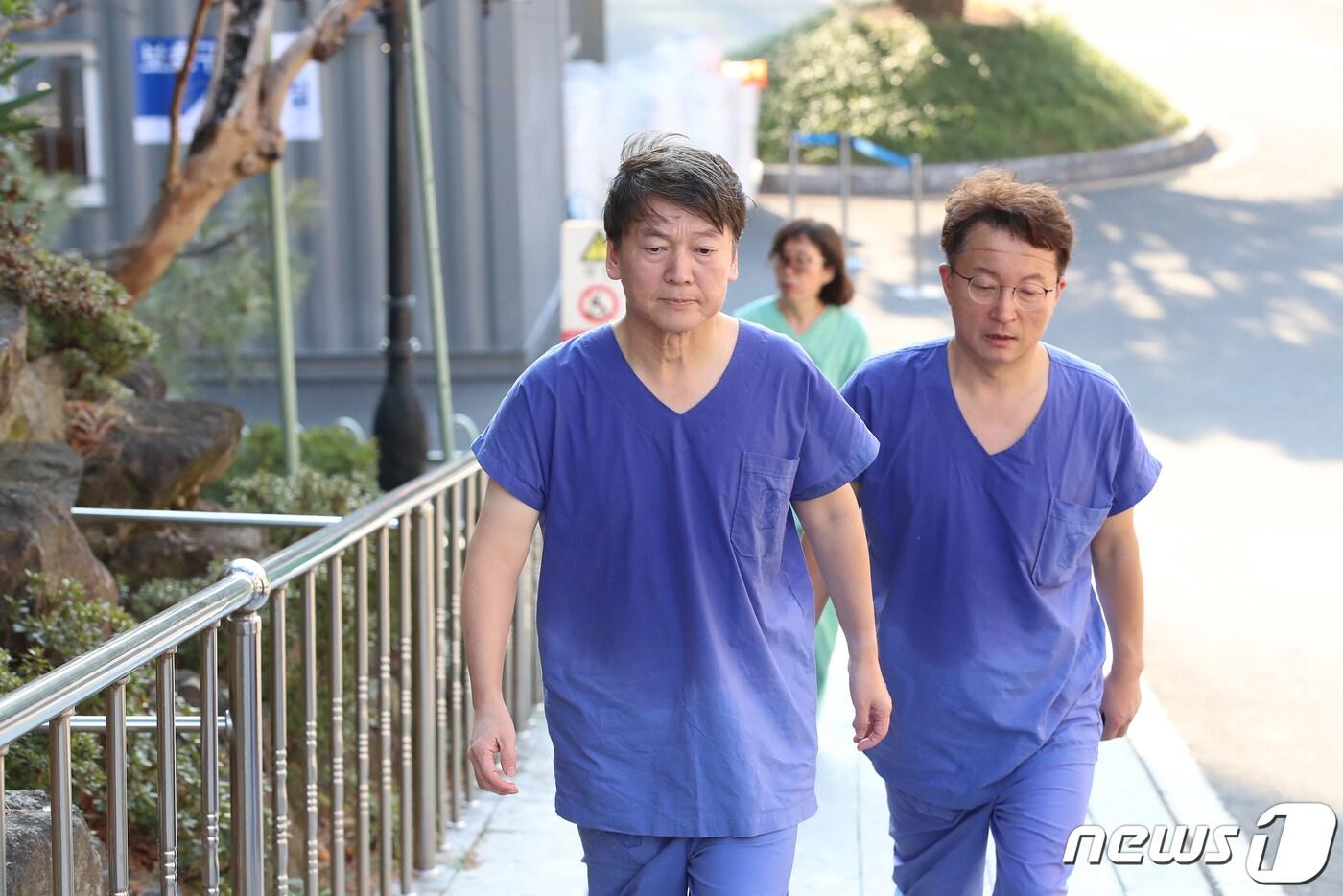 본문 이미지 - 안철수 국민의당 대표(왼쪽)가 2일 오후 신종 코로나바이러스 감염증(코로나19) 지역거점병원인 대구 중구 계명대 대구동산병원을 찾아 병동 내부에서 의료봉사를 마친 뒤 땀에 흠뻑 젖은 모습으로 비상대책본부를 향해 걷고 있다. 2020.3.2/뉴스1 ⓒ News1 공정식 기자