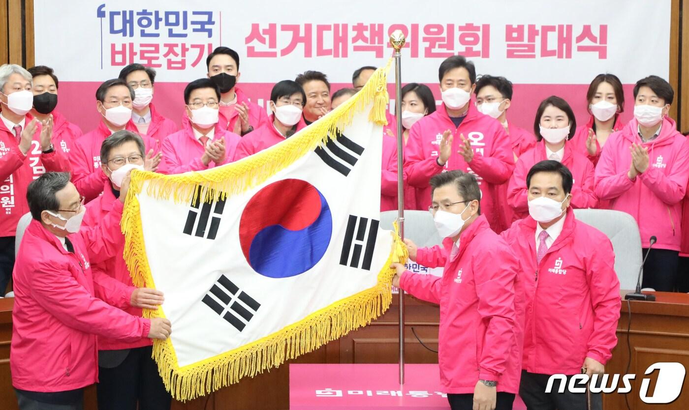 본문 이미지 - 황교안 미래통합당 대표가 20일 서울 여의도 국회에서 열린 제21대 국회의원선거 중앙선거대책위원회 발대식에서 공동선대위원장, 권역별 선대위원장, 최고위원들과 태극기 바로세우는 퍼포먼스를 하고 있다. 황교안 대표가 총괄 위원장으로서 전체 선거를 지휘하고 심재철 원내대표와 함께 박형준 전 혁신통합추진위원장, 신세돈 숙명여대 경제학부 명예교수가 공동선대위원장을 맡았다. 2020.3.20/뉴스1 ⓒ News1 김명섭 기자