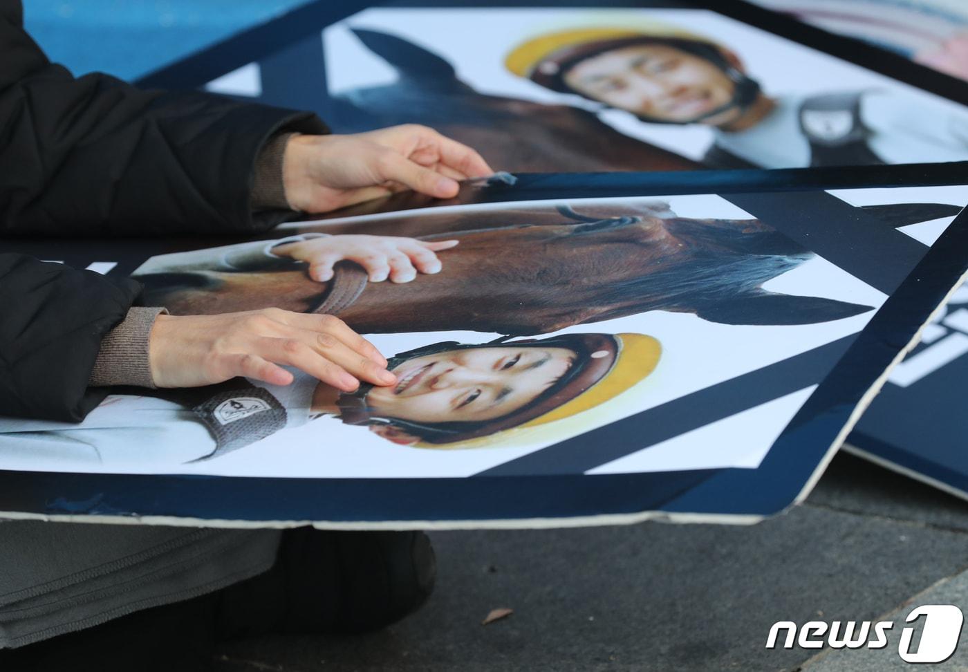 본문 이미지 - 고(故) 문중원 기수 부인 오은주 씨가 서울 종로구 정부서울청사 앞 시민분향소에서 고 문중원 기수의 영정사진을 어루 만지고 있다./뉴스1 ⓒ News1 DB