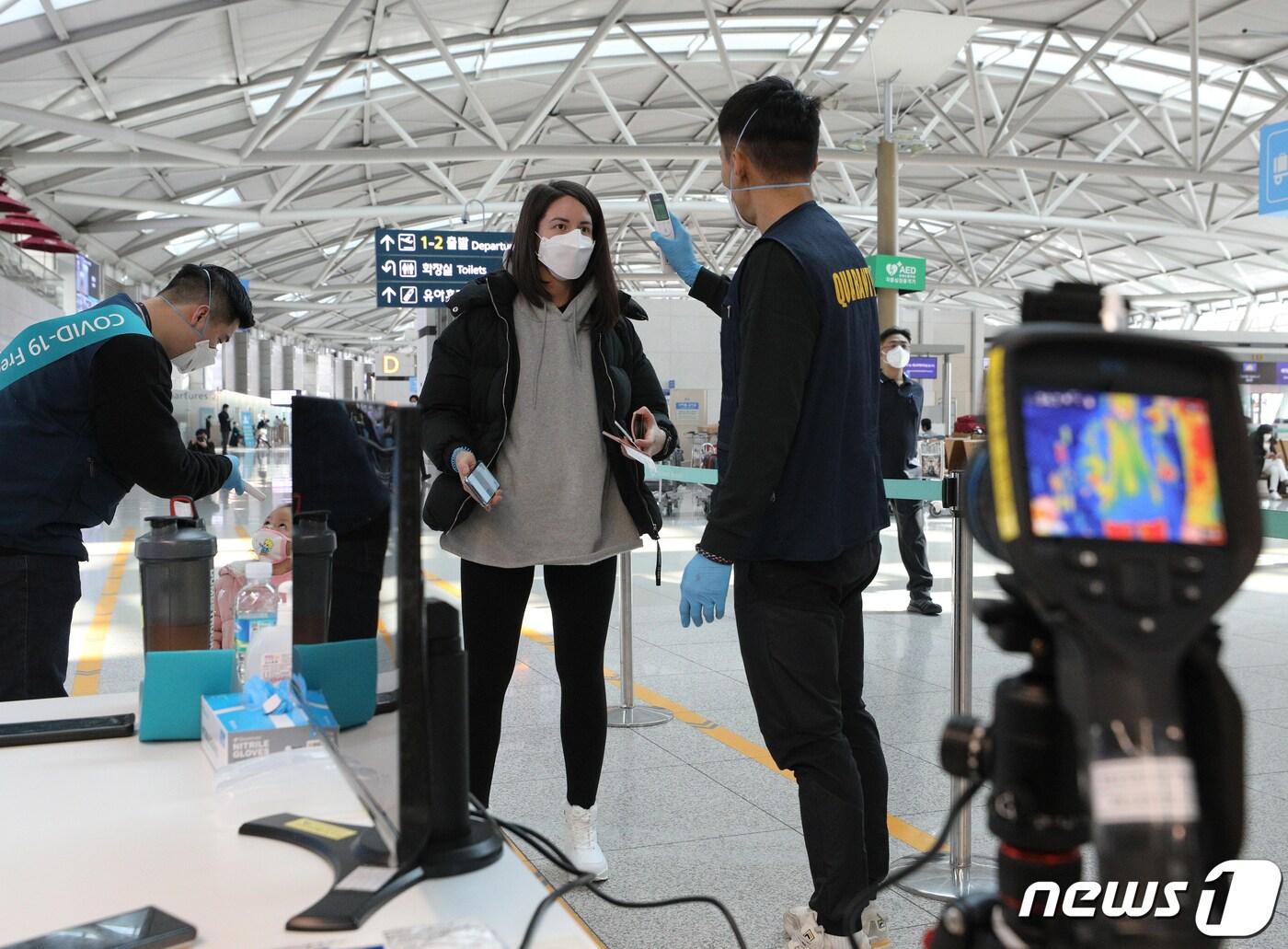 본문 이미지 - 신종 코로나바이러스 감염증(코로나19)이 확산하고 있는 가운데 5일 인천국제공항 1터미널 출국장에서 탑승객들이 체온을 재고 있다. 2020.3.5/뉴스1 ⓒ News1 신웅수 기자