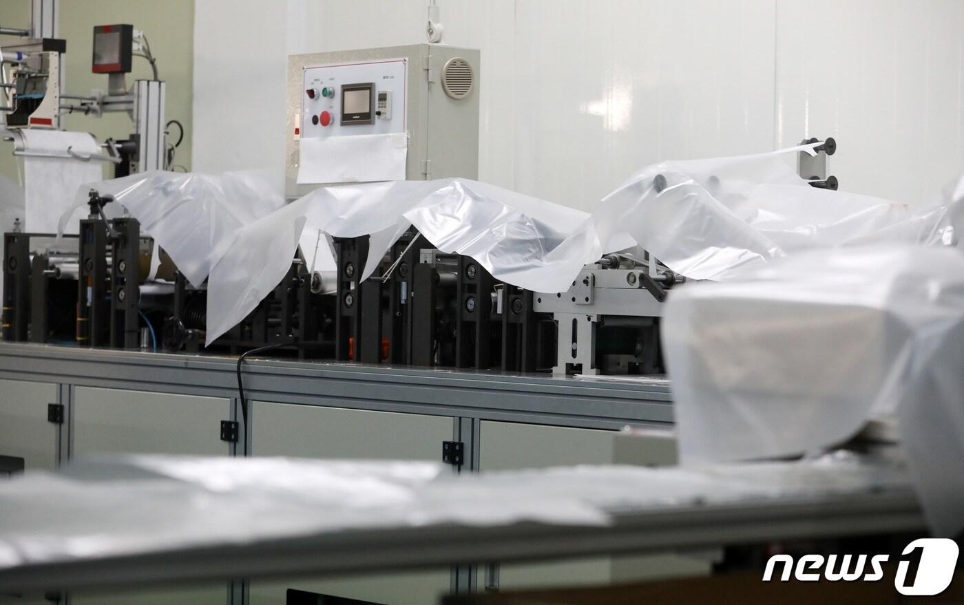 5일 오후 경기도 광주시 소재 한 마스크 제조업체에서 관계자가 마스크 제조의 핵심 재료인 멜트블로운(Melt Blown·MB) 필터가 부족해 공장 가동을 멈춘 채 생산라인이 비닐로 덮여 있다. 2020.3.5/뉴스1 ⓒ News1 조태형 기자