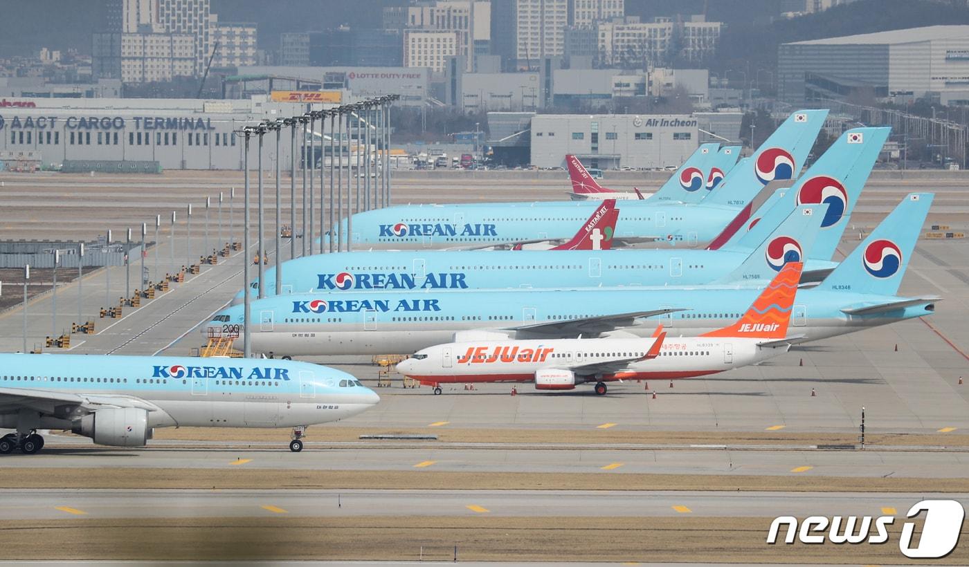 본문 이미지 - 7일 인천국제공항 제1터미널 활주로에 항공기들이 계류돼 있다. 국내 항공사의 일본행 노선이 오는 9일부터 대부분 중단된다. 일본이 한국인의 무비자 입국을 막고 ‘2주 격리’ 등 사실상 입국제한 조처를 취한 여파다. 대한항공은 28일까지 인천~나리타(주 7회) 노선을 제외한 일본 노선을 아시아나항공은 31일까지 일본 왕복 전체 노선의 운항을 중단하기로 결정했다. 2020.3.7/뉴스1 ⓒ News1 성동훈 기자