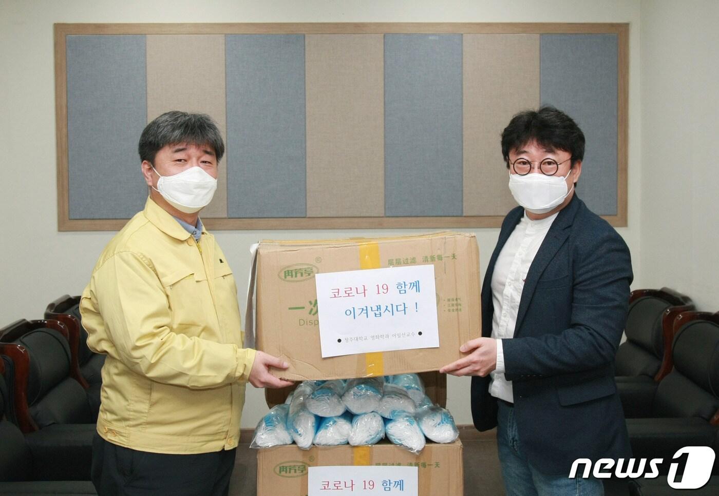 청주대학교 어일선 영화학과 교수(오른쪽)가 1일 중국인 유학생 제자가 보내온 마스크 1만5000장을 곽노준 국제교류처장에게 전달하고 있다.(청주대학교 제공).2020.4.1/뉴스1