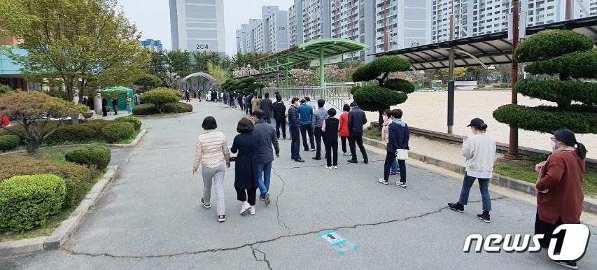 본문 이미지 - 21대 국회의원선거 사전투표 이틀째인 지난 11일 오후 광주 서구 전남중학교에 마련된 치평동 사전투표소 앞에 투표하려는 시민들이 길게 줄을 서고 있다.2020.4.11/뉴스1 ⓒ News1 박준배 기자
