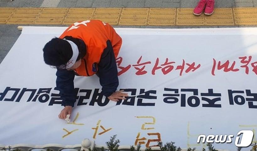 본문 이미지 - 2020년 4월 12일 이은재 한국경제당 대표가 서울 서초동 대검찰청 앞에서 범여권에 맞서 윤석열 검찰총장을 지켜내겠다며 '혈서'를 쓰고 있다. 이 대표는 새누리당-바른정당-자유한국당(국민의힘 전신)을 '사퇴하세요'라는 유행어를 남겨 '사퇴 요정'으로 불렸다. ⓒ 뉴스1 DB