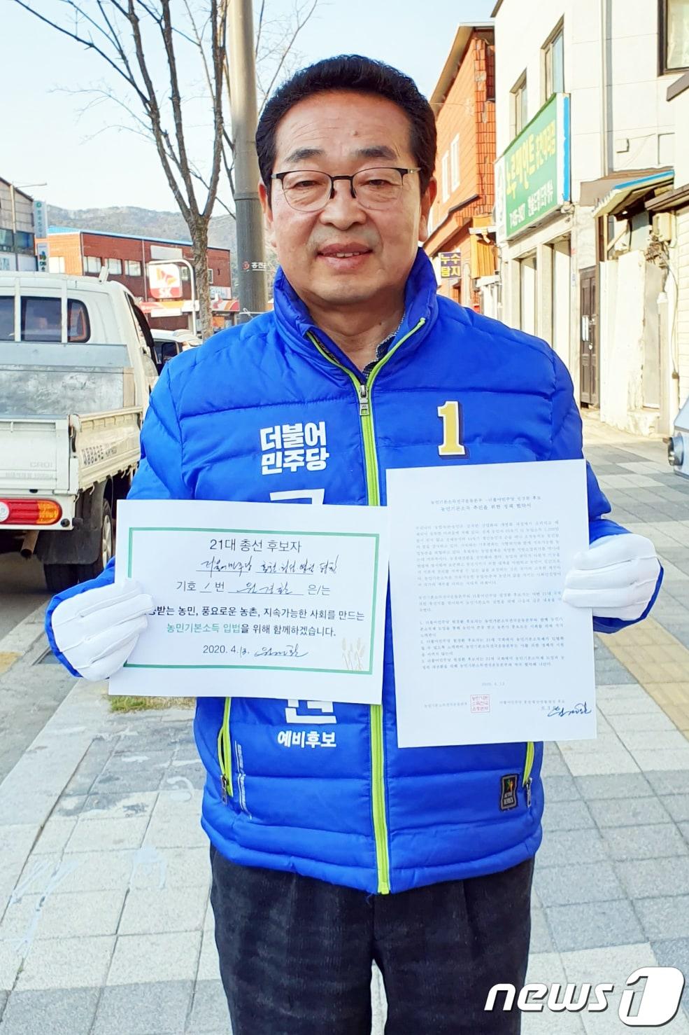 본문 이미지 - 원경환 더불어민주당 국회의원 후보(강원 홍천·횡성·영월·평창)는 지난 13일 농민기본소득전국운동본부와 ‘농민기본소득 추진을 위한 정책 협약’을 체결한 뒤 협약서를 내보이고 있다. ⓒ News1 