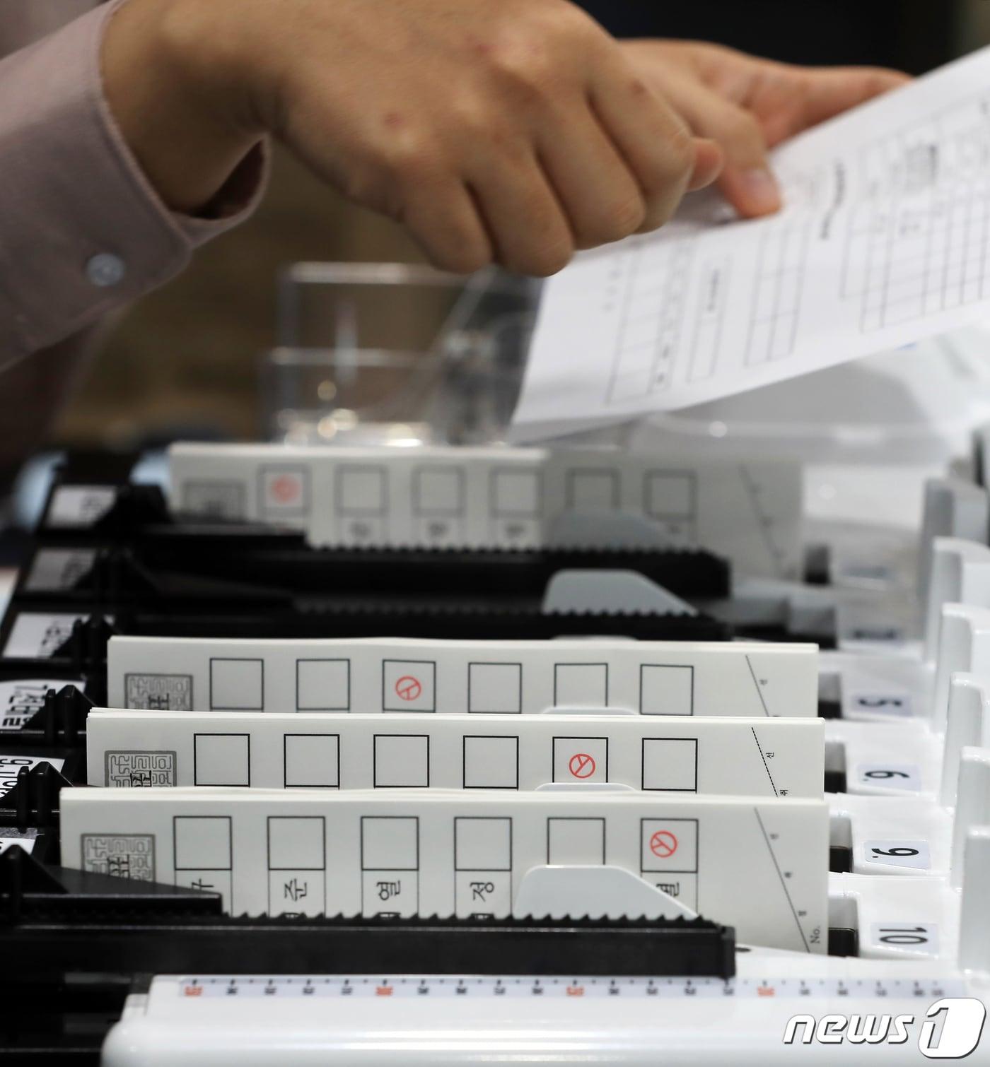 본문 이미지 - 제21대 국회의원선거일을 하루 앞둔 14일 서울 강남구 세텍&#40;SETEC&#41;에 제1전시장에 마련된 선관위 개표소에서 개표사무원이 시연용 투표용지로 투표지분류기 모의시험을 하고 있다. 2020.4.14/뉴스1 ⓒ News1 구윤성 기자