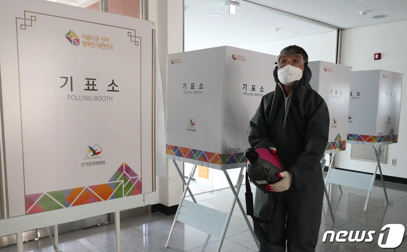 제21대 국회의원 선거를 하루 앞둔 14일 오후 대전 유성구 덕송초등학교에 마련된 투표소에서 방역업체 관계자가 소독 작업을 하고 있다. 2020.4.14/뉴스1 ⓒ News1 김기태 기자