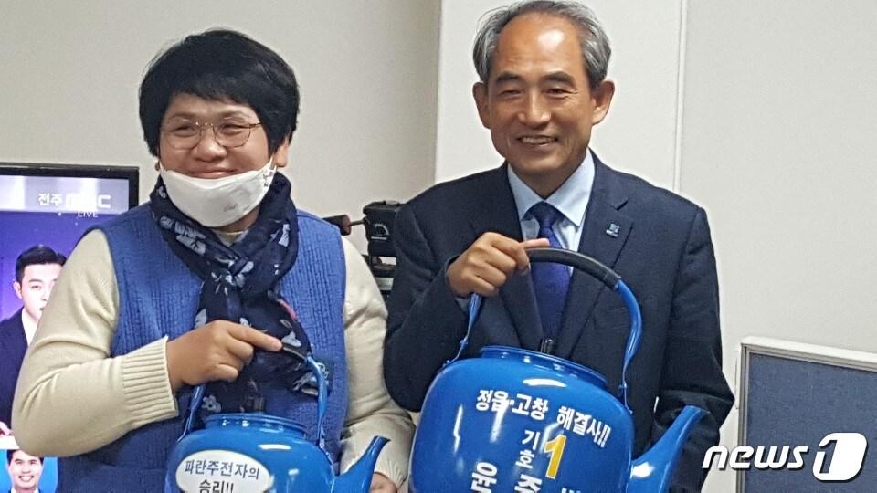 본문 이미지 - 21대 총선에 처음 도전한 더불어민주당 정읍고창 윤준병 당선인이 3선의 민생당 유성엽 후보를 압도적인 표차이로 누르며 국회 첫 입성의 꿈이 이뤘다.  윤 당선자와  부인 정경임씨가 트레이드마크인 '파란주전자'를 들고 기뻐하고 있다.  /ⓒ 뉴스1