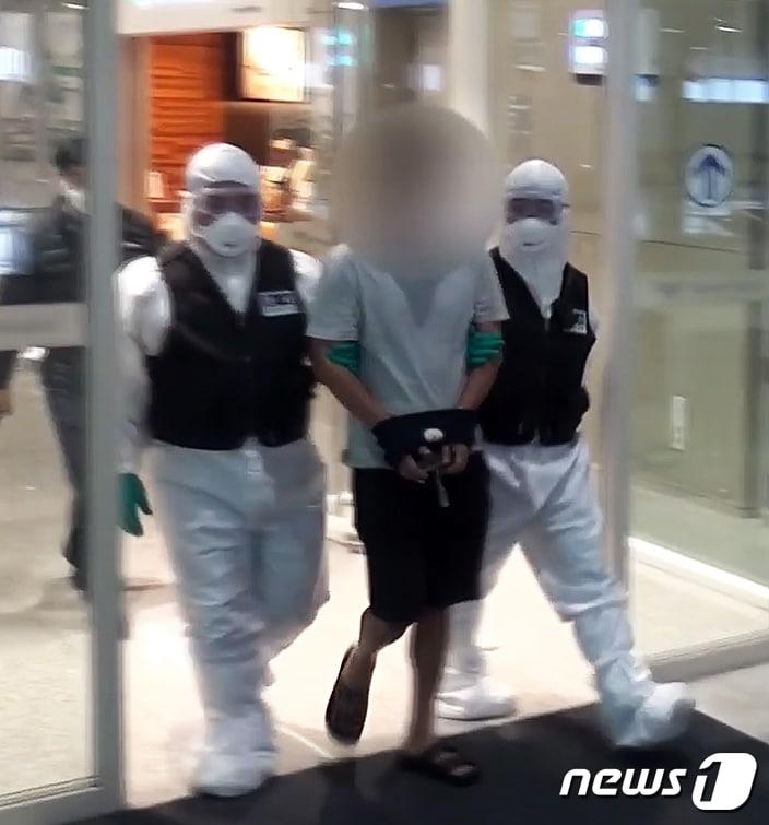 본문 이미지 - 경찰이 지난 14일 국제사이버범죄조직 총책으로 알려진 56살 A씨가 태국에서 국내로 압송되는 장면을 공개했다. A씨는 무려 14년 동안 국내에 들어오지 않고, 태국, 베트남 등지에서 조직적으로 국제 사이버 범죄 조직을 운영한 혐의 등을 받고 있다. A씨 체포 작전에 나선 경찰은 코로나19 감염 가능성을 우려해 전신 방호복에 고글, 마스크를 착용하는 등 철저한 방역 절차를 밟았다. (경기북부경찰청 제공) 2020.4.21/뉴스1